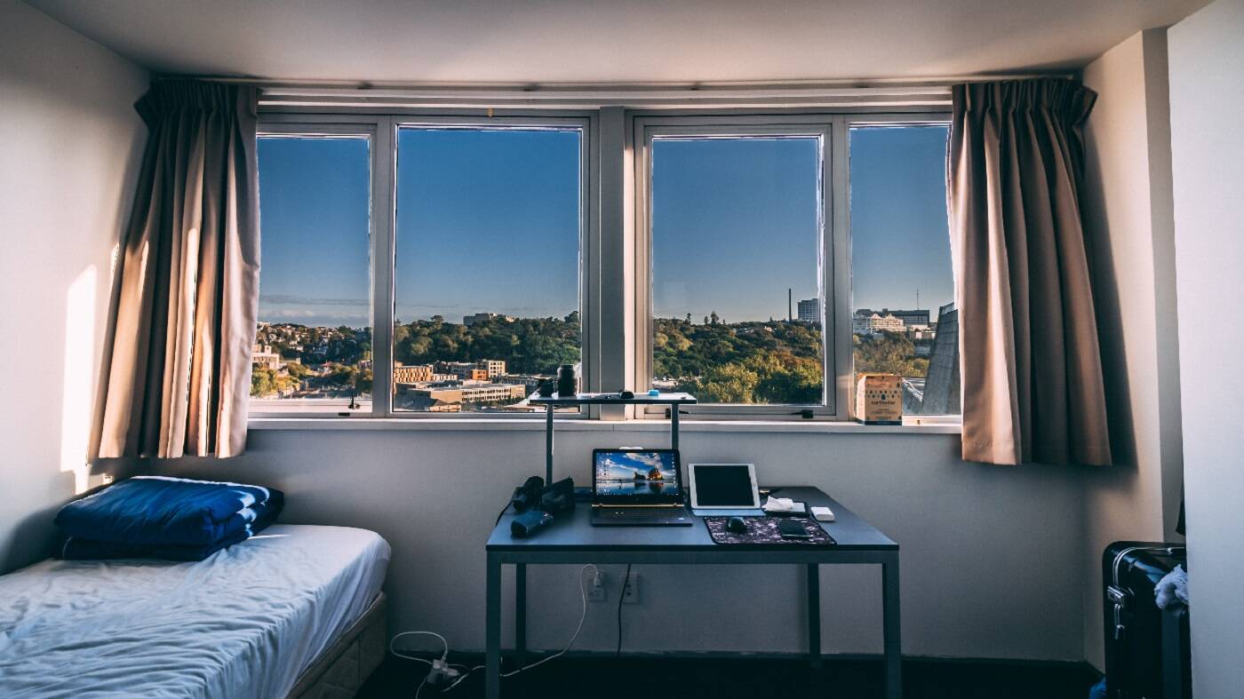 Dorm room with laptop and thick curtains