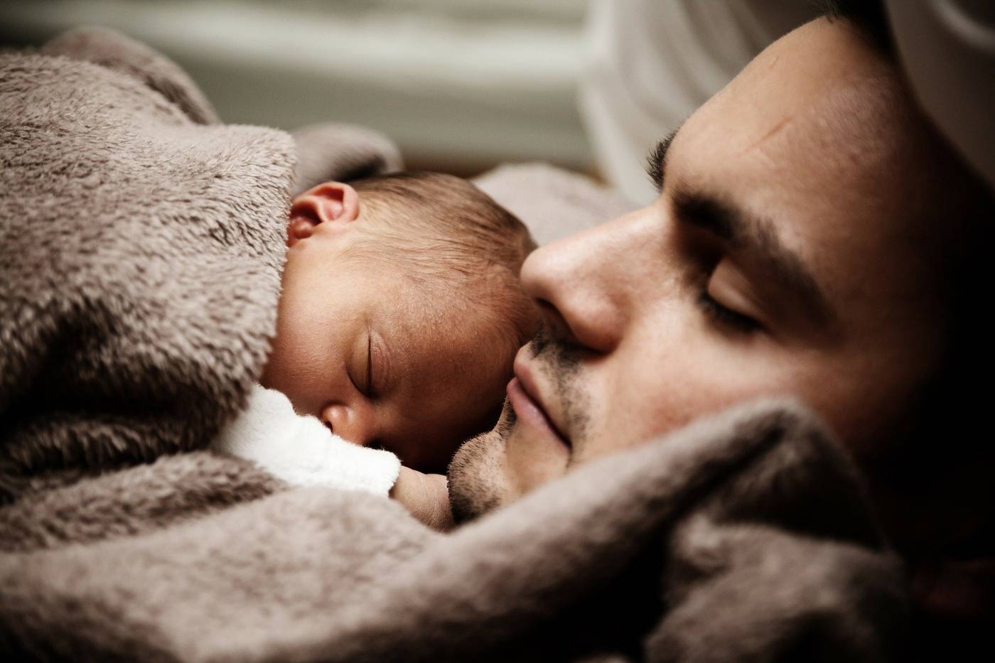 Father and baby sleeping in bed